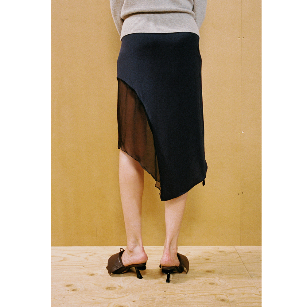 Close up of a lady wearing the Delusion skirt against a wooden backdrop