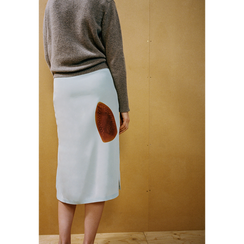 Close up of a lady wearing the Iron Burn skirt against a wooden backdrop 