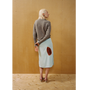 Lady wearing the Armour Knit and Iron Burn Skirt in front of a wooden backdrop