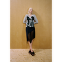 Lady wearing the grey Kissing Cardigan and navy Delusion Skirt leaning against a wooden wall