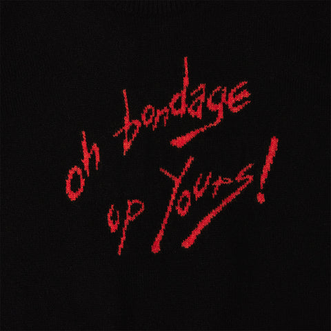 Close up of the text from the 'Oh Bondage, Up Yours!' jumper in black and orange