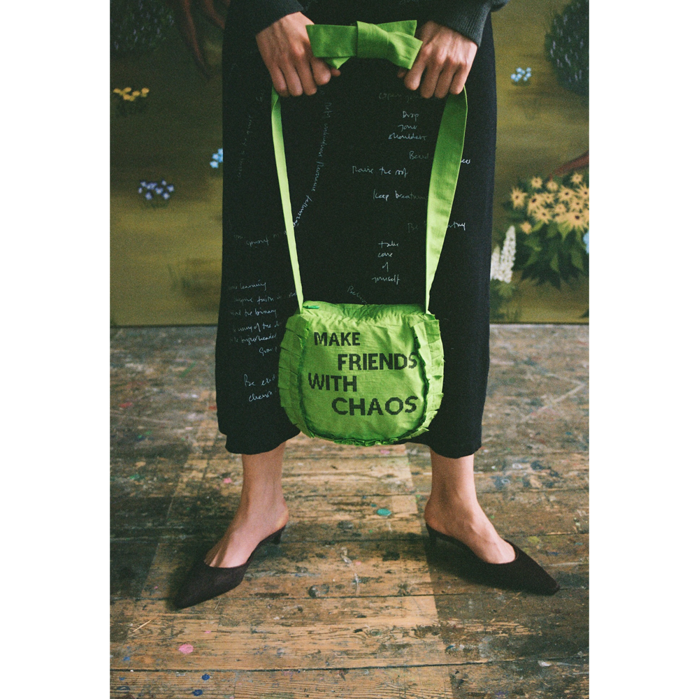 Model holding the "Make Friends With Chaos" bag.